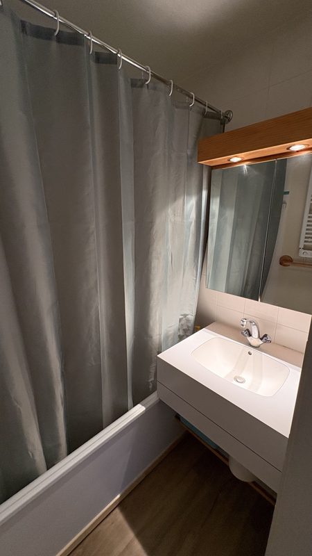 La salle de bain avec sa baignoire-douche et son lavabo